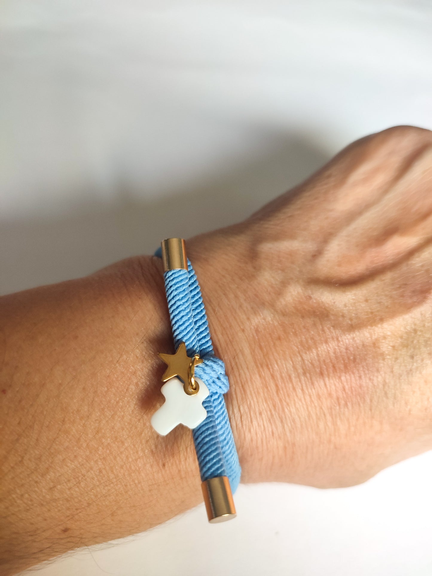 Pulsera nudo CRUZ NÁCAR Y ESTRELLA DORADA